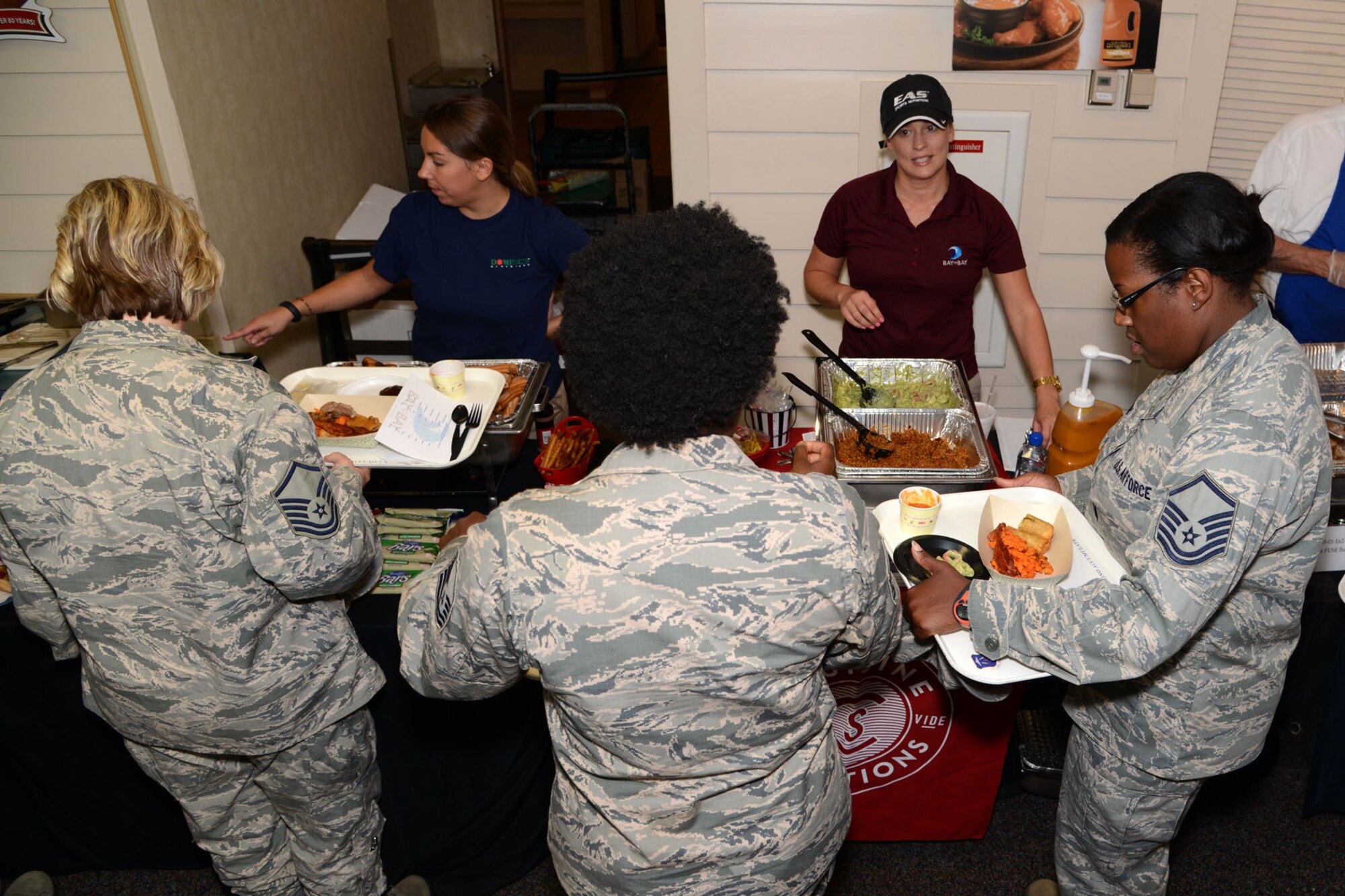 U.S. Air Force senior noncommissioned officers take food samples from potential dining facility vendors at the Inaugural Langley Air Force Base Food Show at Langley Air Force Base, Va., Aug. 27, 2014. The Crossbow Dining Facility staff held the event to solicit feedback from Airmen and decide which vendors to contract for new food supply. (U.S. Air Force photo by Airman 1st Class Devin Scott Michaels)(This photo was cropped to emphasize the subject and the levels were adjusted for aesthetic purposes)