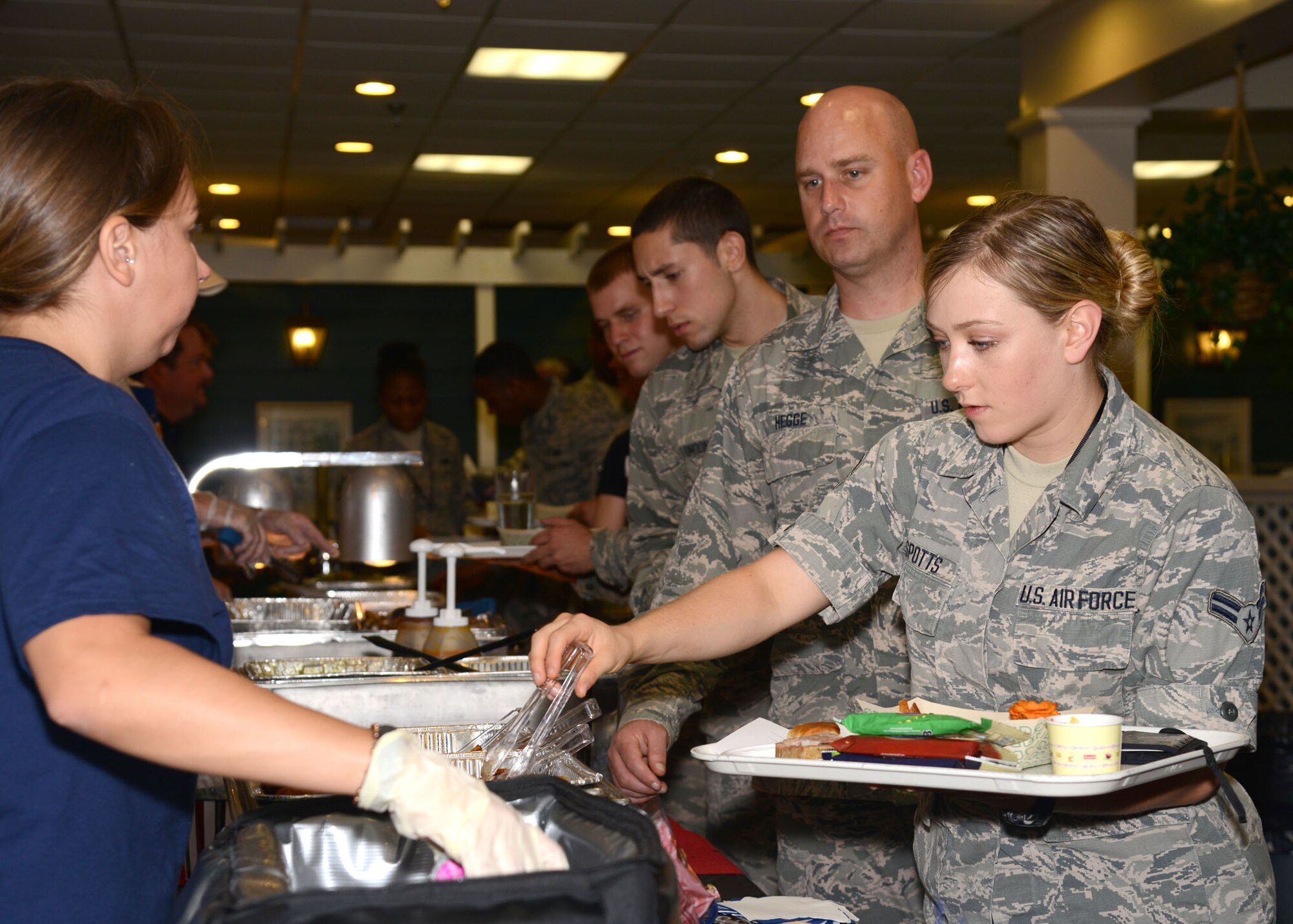 U.S. Air Force Airman 1st Class Jamie Spotts, 45th Intelligence Squadron geospacial analyst, receives a food sample from a vendor at the Inaugural Langley Air Force Base Food Show at Langley Air Force Base, Va., Aug. 27, 2014. All of the food items presented were made with lower sodium contents, less fat and less sugar. (U.S. Air Force photo by Airman 1st Class Devin Scott Michaels)(This photo was cropped to emphasize the subject and the levels were adjusted for aesthetic purposes)