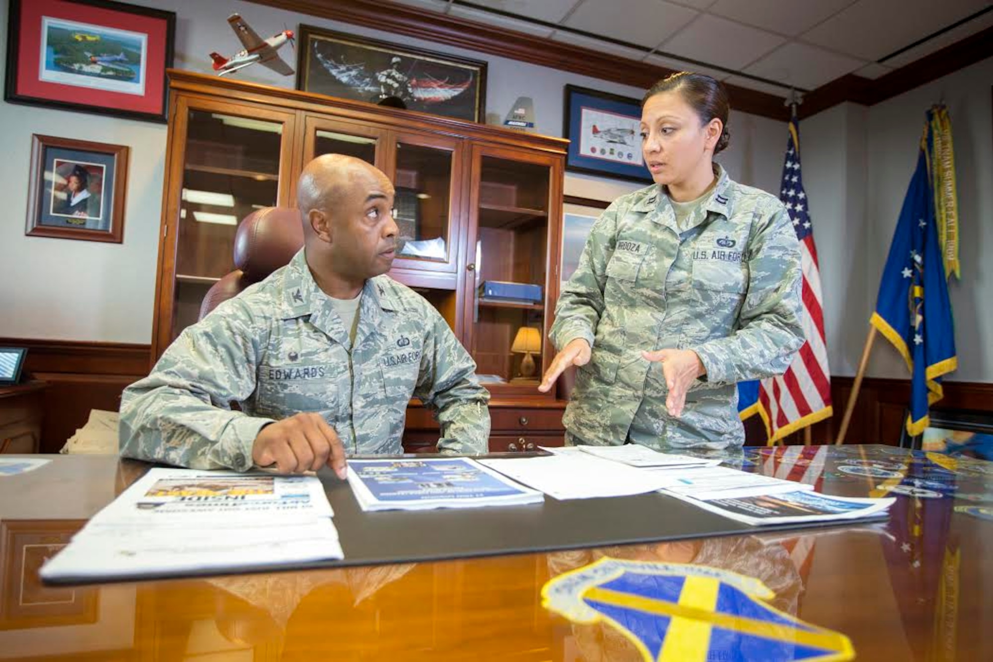 Capt. Monica Verdoza,executive aide to the 37th Training Wing commander, provides Col. Trent Edwards, 37th TRW commander with the morning updates.  Edwards took command of the 37th TRW in June 2014. (U.S. Air Force Photo by Joshua Rodriguez/Released)