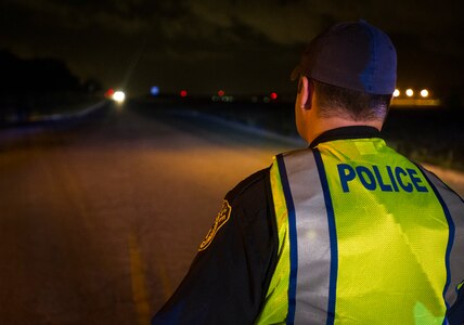 Andrew A. Drew 628th Security Forces Squadron patrolman waits as a car pulls up to a DUI checkpoint, Aug. 29, 2014, in North Charleston. The joint checkpoint allowed for officers from different agencies to gain a better understanding of how each department works. Holding DUI checkpoints help deter drivers from drinking and driving. (U.S. Air Force photo/Staff Sgt. William O'Brien)