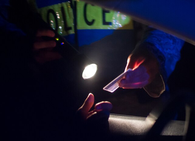 An officer checks a driver’s license during a DUI checkpoint, Aug. 29, 2014, in North Charleston. The checkpoint was held as a joint effort between 628 SFS patrolmen and local sheriffs and police officers. (U.S. Air Force photo/Staff Sgt. William O'Brien)