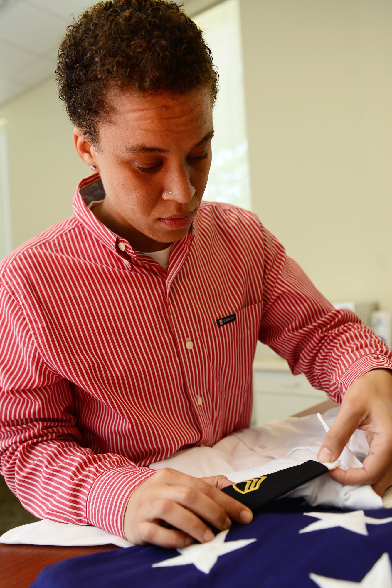 Amber Hendricks, Army Support Activity mortuary affairs coordinator, ensures a rank is properly placed on a uniform shirt at Fort Eustis, Va., Aug. 26, 2014. Hendricks’ duties include making sure the uniform of a deceased U.S. Army Soldier is in proper order and making arrangements for the Service member’s family to attend the funeral. (U.S. Air Force photo by Airman 1st Class Kimberly Nagle/Released)   

