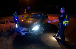 Robert Clark, 628th Security Forces Squadron patrolman, stops a car as it pulls up to a DUI checkpoint, Aug. 29, 2014, in North Charleston. The checkpoint was held as a joint effort between 628th Security Forces Squadron patrolmen and local sheriffs and police officers.  (U.S. Air Force photo/Staff Sgt. William O'Brien)