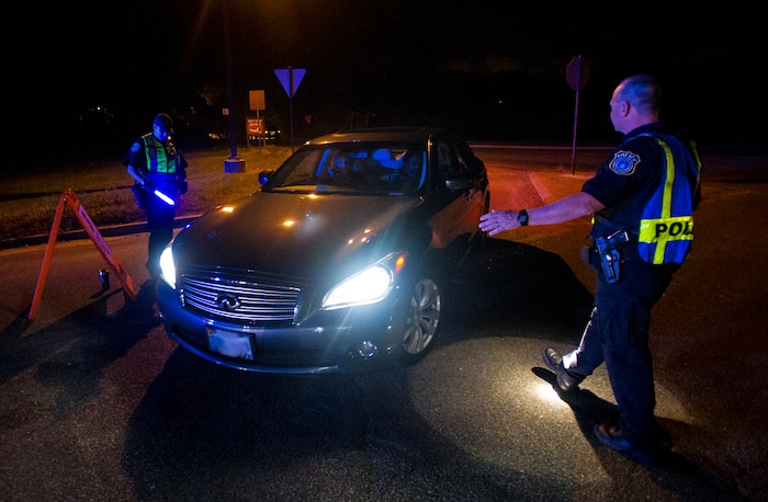Robert Clark, 628th Security Forces Squadron patrolman, stops a car as it pulls up to a DUI checkpoint, Aug. 29, 2014, in North Charleston. The checkpoint was held as a joint effort between 628th Security Forces Squadron patrolmen and local sheriffs and police officers.  (U.S. Air Force photo/Staff Sgt. William O'Brien)