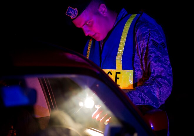 Senior Airman Michael Compson, 628th Security Forces Squadron patrolman, checks a driver’s license during a DUI checkpoint, August 29, 2014, in North Charleston. The checkpoint was held as a joint effort between 628th SFS patrolmen and local sheriffs and police officers. (U.S. Air Force photo/Staff Sgt. William O'Brien)