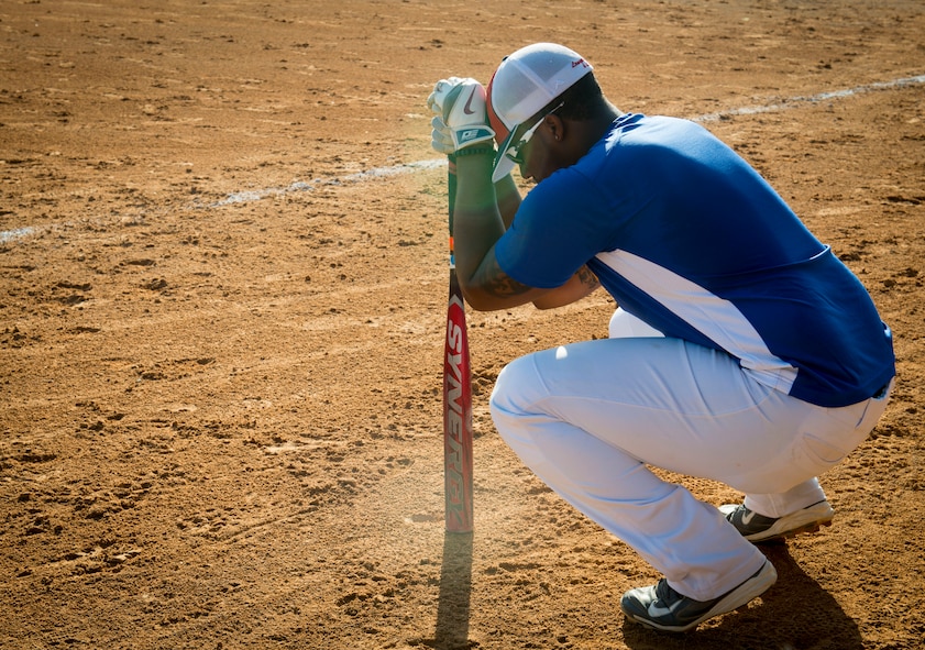 Senior Airman Lorenzo Small, 705th Munitions Squadron softball team member, prepares to take his place at bat at Minot Air Force Base, N.D., Aug. 26, 2014. After a tough first game, Small took a moment collect his thoughts before stepping up to home plate. (U.S. Air Force photo/Airman 1st Class Sahara L. Fales)