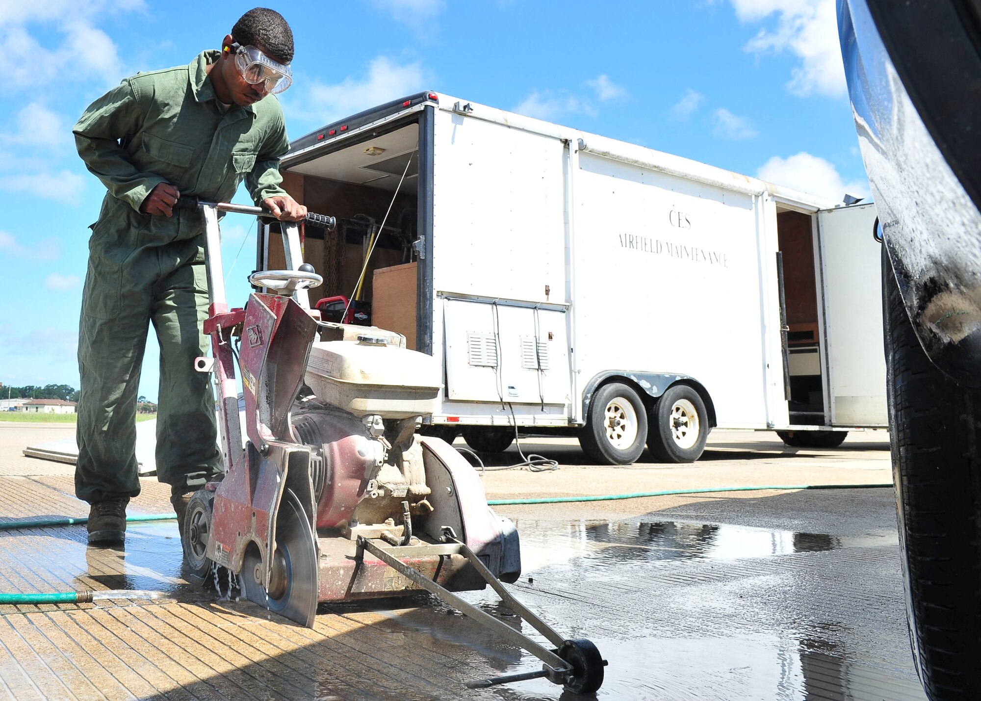 U.S. Air Force Senior Airman DaQuan Price, 633rd Civil Engineer Squadron pavements and equipment craftsman, cuts a section of the runway at Langley Air Force Base, Va., Aug. 27, 2014.  The 633rd CES closed the runway to patch damaged areas preventing foreign object debris from damaging aircraft. (U.S. Air Force photo by Senior Airman Connor Estes/Released)