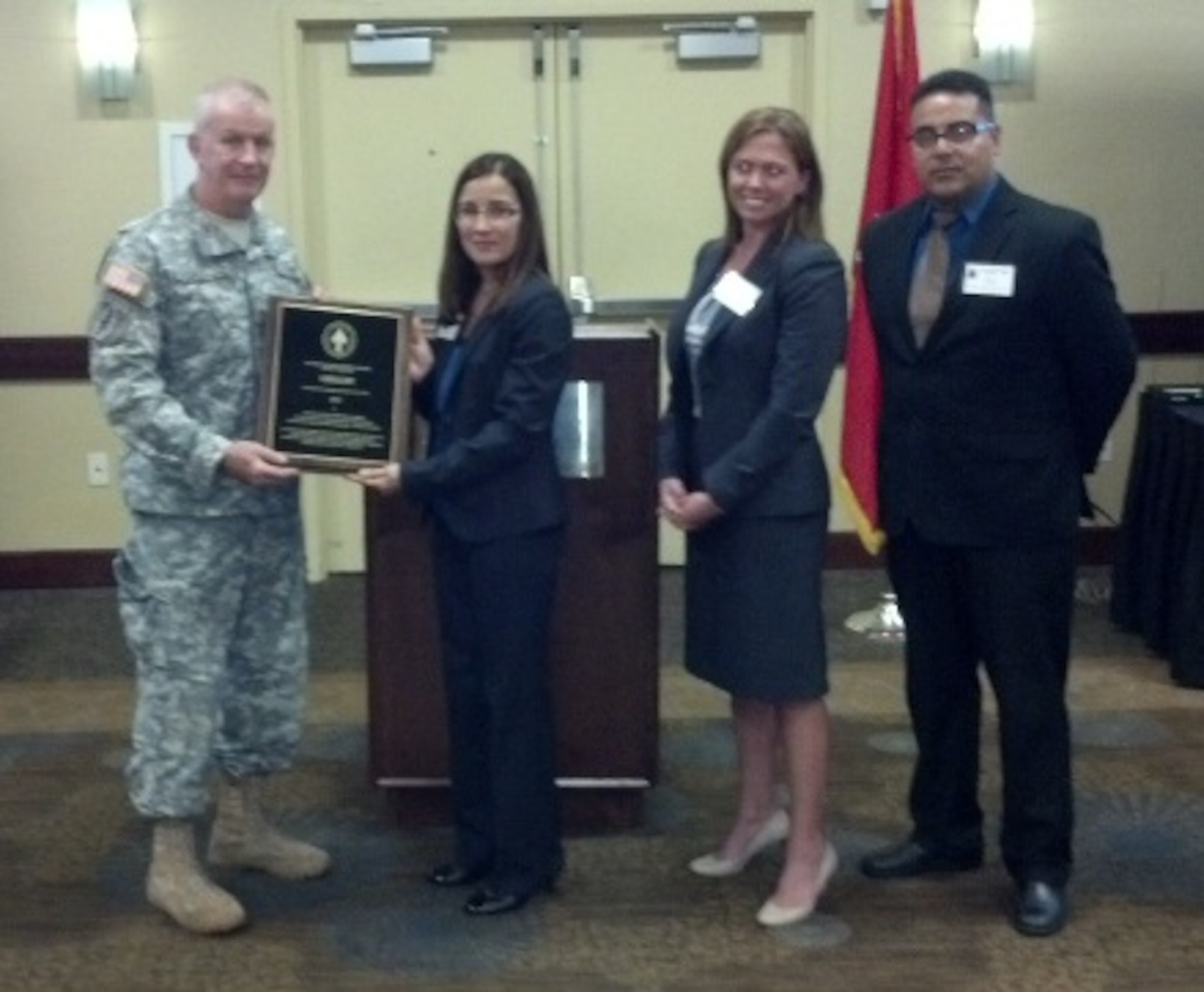 Army Brig. Gen. Sean Mulholland, Special Operations Command South commanding general, presents the Special Operations Command Institutional Language Program of the Year Award to Grisel Mundo-Love, U. S. Air Force Special Operations School Language Center director, Alicia N. Spurling, Air Force Special Operations Command language manager, and Mohammed L. Slassi, Hurlburt Field's Defense Language Institute Language Training Detachment director Aug. 11, 2014, in Tampa, Fla. The USAFSOS Language Center at Hurlburt Field, Fla., won the language program award for its achievements between July 31, 2013 and Aug. 1, 2014.  This is the second time the school has taken this honor.  (Courtesy photo)