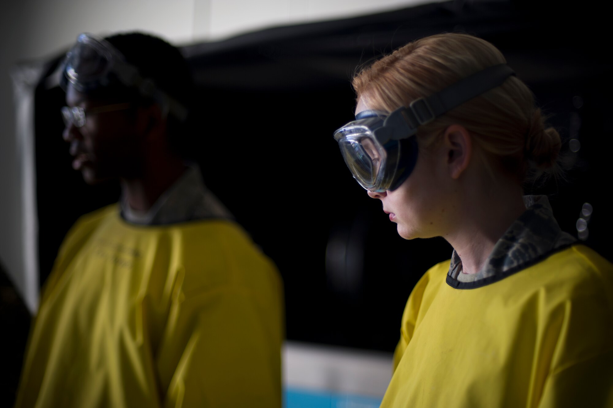 Airman 1st Classes Clarence Tobias and Courtney Harrah, 5th Maintenance Squadron non-destructive inspection apprentices, perform a Cracked Chrome Panel test for the stationary fluorescent penetrant inspection line.  The purpose of this test is to evaluate our in use inspection materials against a control set.(U.S. Air Force photo/Senior Airman Brittany Y. Bateman)