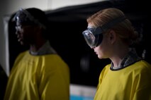 Airman 1st Classes Clarence Tobias and Courtney Harrah, 5th Maintenance Squadron non-destructive inspection apprentices, perform a Cracked Chrome Panel test for the stationary fluorescent penetrant inspection line.  The purpose of this test is to evaluate our in use inspection materials against a control set.(U.S. Air Force photo/Senior Airman Brittany Y. Bateman)