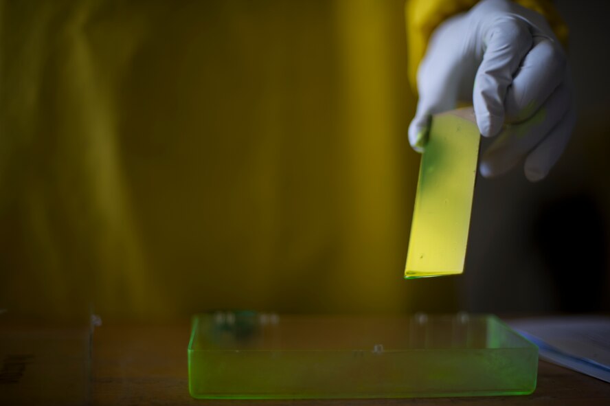 Airman 1st Class Courtney Harrah, 5th Maintenance Squadron non-destructive inspection apprentice, performs a Cracked Chrome Panel test for the stationary fluorescent penetrant inspection line.  The purpose of this test is to evaluate our in use inspection materials against a control set. (U.S. Air Force photo/Senior Airman Brittany Y. Bateman)