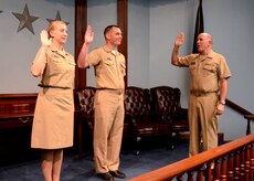 Surgeon General of the Navy, Vice Adm. Matthew Nathan (right), administers the officer’s oath to Lt. j.g. Erin Hudson (left) and Lt. Cameron Barnett during a re-commissioning ceremony Aug. 27, 2014, in the Rickover Memorial Auditorium at the Naval Nuclear Power Training Command on Joint Base Charleston, S.C. Hudson and Barnett are changing career fields from Nuclear Power School instructors to become Radiation Health Officers in the Navy’s Medical Service Corps. (U.S. Navy photo/Petty Officer 2nd Class Jason Pastrick)