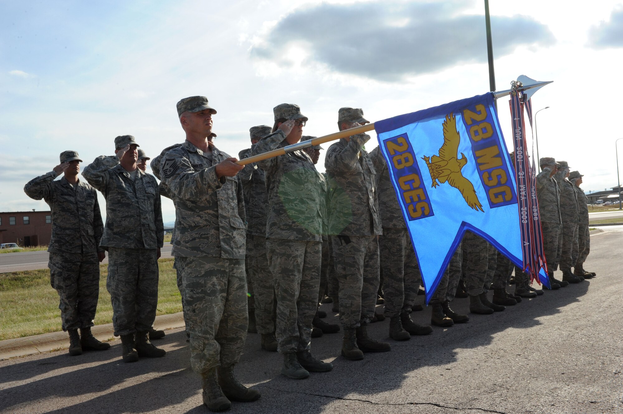 Personnel from the 28th Civil Engineer Squadron salute the flag during the playing of retreat at Ellsworth Air Force Base, S.D., Aug. 26, 2014. Each month, one squadron on base holds the ceremony at the base flagpole to remember and honor its Air Force heritage. (U.S. Air Force photo by Senior Airman Hailey R. Staker/Released)