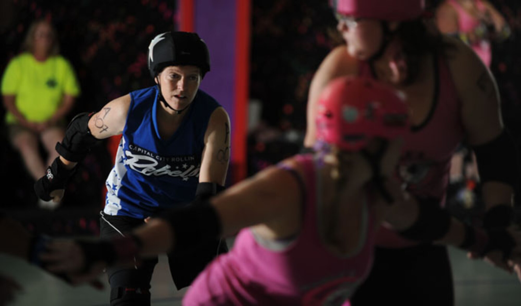 Lt. Col. Melanie Friedman, Curtis E. Lemay Center for Doctrine Development and Education deputy director of intelligence, gets ready to ‘jam’ past her opponents during the Capitol City Rollin’ Rebels and Mobile Derby Darlins’ roller derby bout Aug. 9, 2014. Friedman is a utility player for the Capitol City Rollin’ Rebels meaning she can play the position of blocker or jammer. The jammers job is to score points by lapping around or through the blockers. The blockers must stop the opposing team’s jammer from lapping, and help their own team’s jammer score points. (U.S. Air Force photo by Staff Sgt. Natasha Stannard)