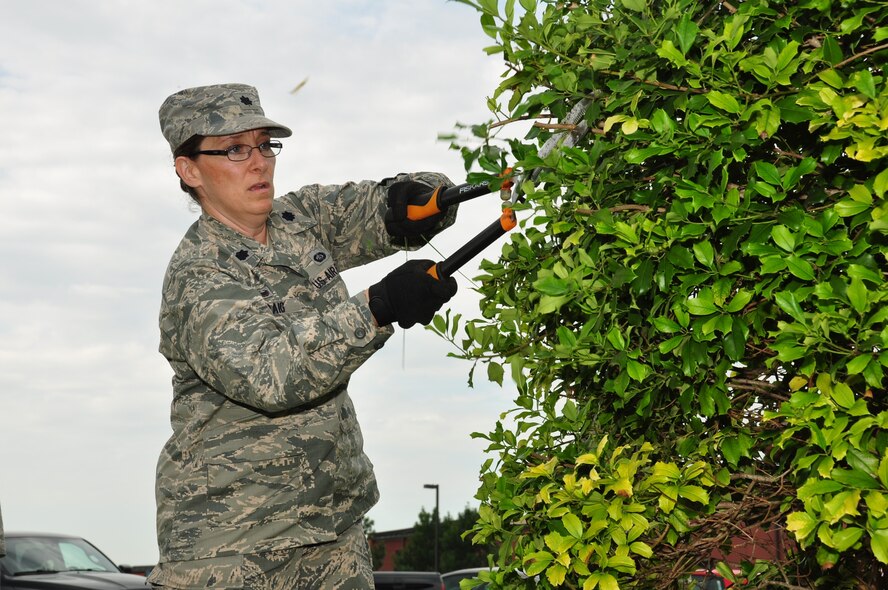 Lt. Col. Lisa Craig helped trim up the hedges in front of the headquarters building during a recent cleaning event at the 932nd Airlift Wing.  Various staff and 932nd Airlift Wing members joined together to work on a self-help project cleaning the grounds in front of the wing headquarters building during a unit training assembly. A large amount of material was cleaned up and the results were quite positive, as seen by many visitors walking by the flagpole. (U.S. Air Force photo/Staff Sgt. Amber Hodges)