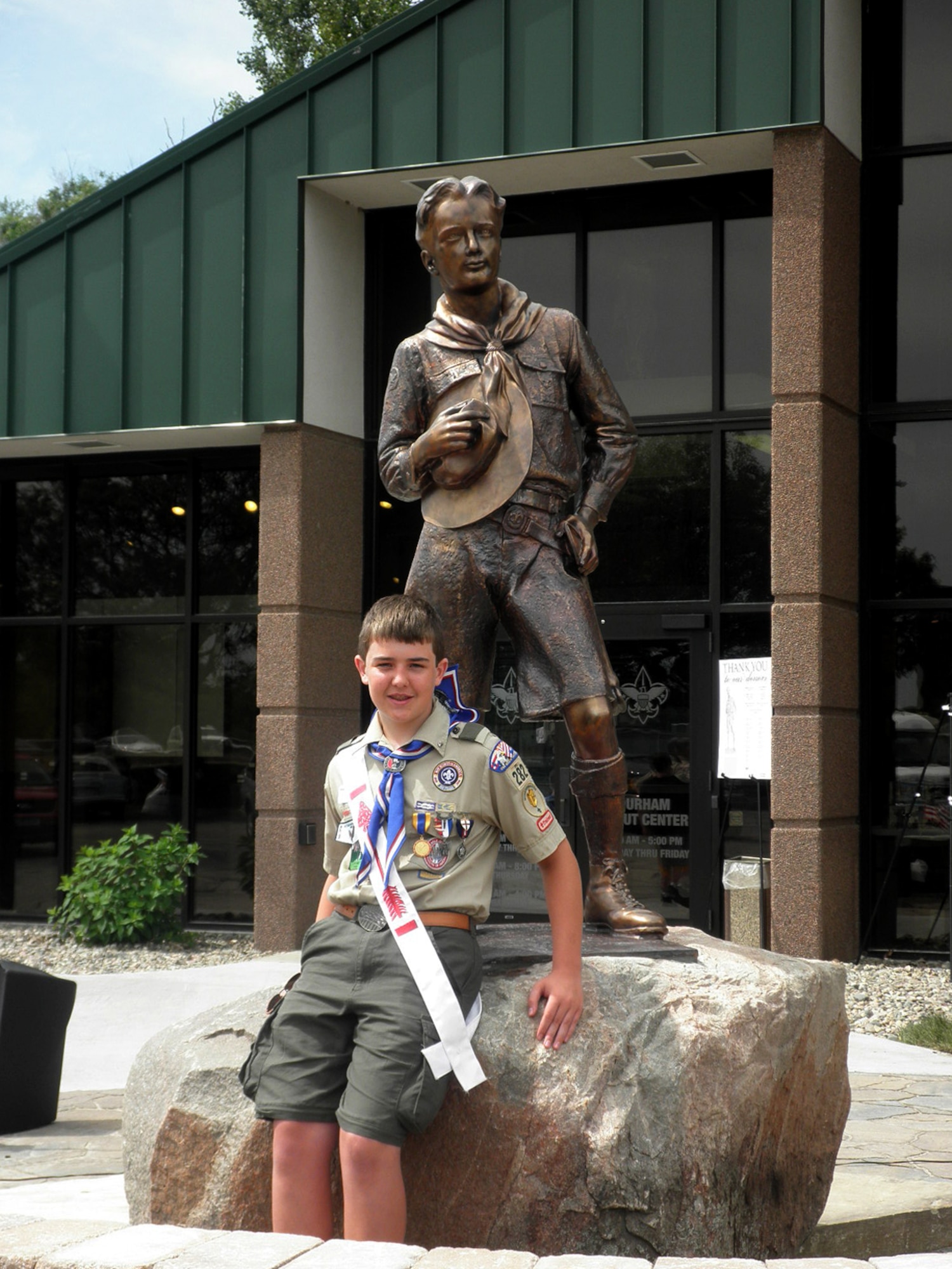 OMAHA, Nebraska – Dillon M. Duermyer, Eagle Scout, 14, poses for a photo next to a Dr. R. Tait McKenzie statue outside of the Mid-America Council Scout Headquarters June 11, 2010. The McKenzie statue is a visual representation of an ideal Boy Scout. The uncovered head represents reverence and obedience; the ax on which the hand rests is a symbol of George Washington's truthfulness. (Courtesy photo)