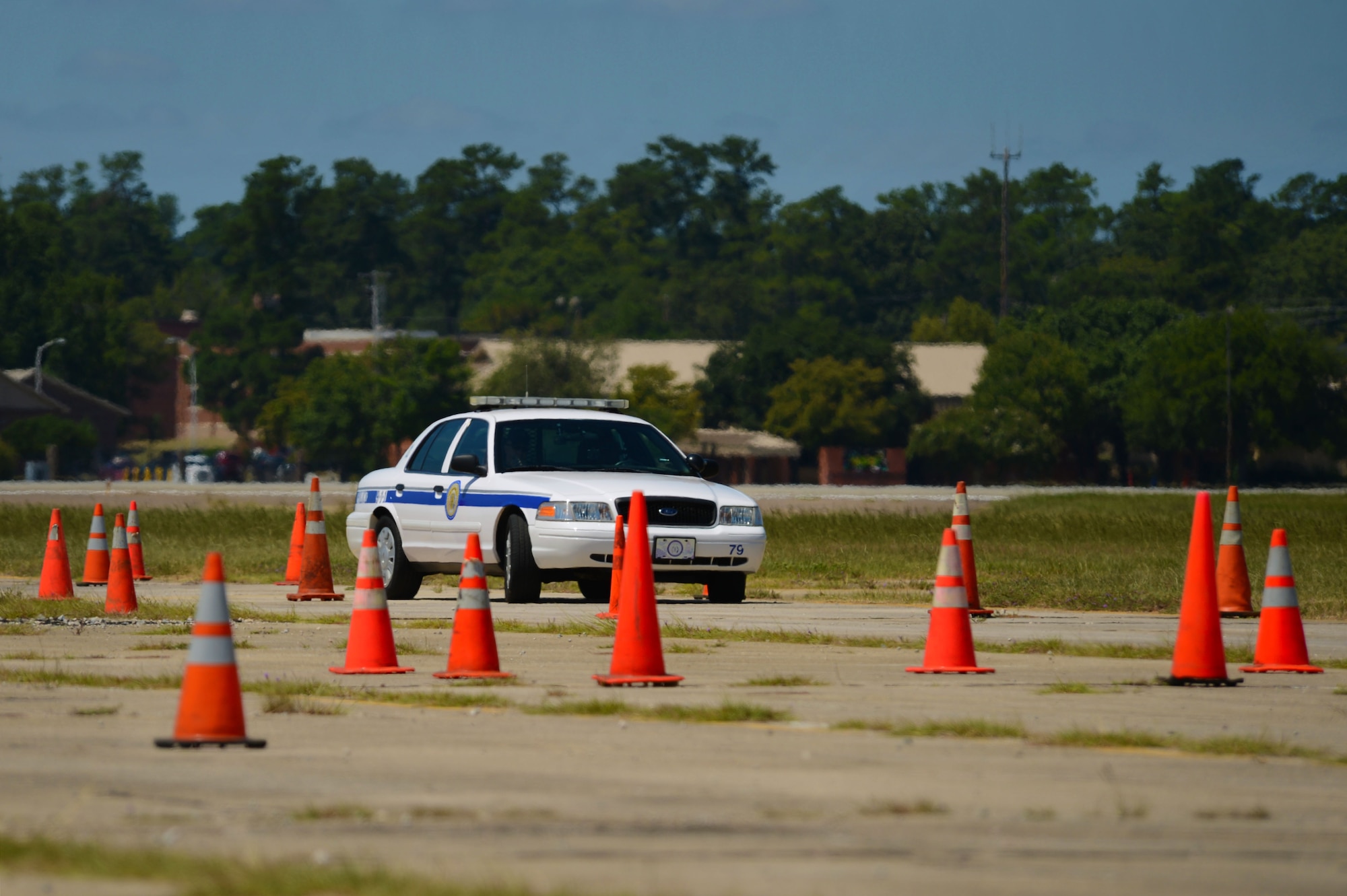 A Sumter Police Department officer maneuvers a patrol vehicle car through a series of traffic cone obstacles during defensive driving training at Shaw Air Force Base, S.C., Aug. 26, 2014. Due to lack of driving space in the city, the Sumter PD uses Shaw to conduct this annual training course. (U.S. Air Force photo by Airman 1st Class Jensen Stidham/Released)