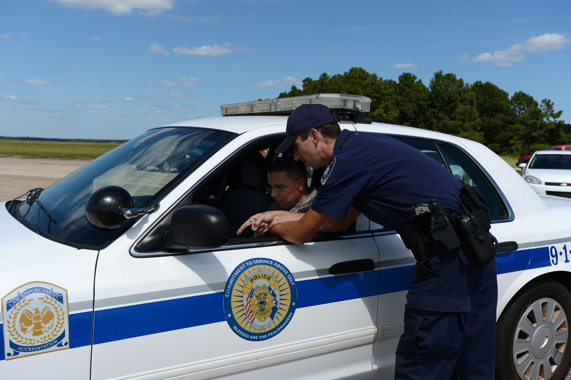 U.S. Air Force Tech. Sgt. Michael Ambriz, 20th Security Forces Squadron flight sergeant, receives instructions from a Sumter Police Department officer at Shaw Air Force Base, S.C., Aug. 26, 2014. After the police officers completed the defensive driving course, Ambriz drove the course, testing his driving skills through the 10 sets of obstacles. (U.S. Air Force photo by Airman 1st Class Jensen Stidham/Released)