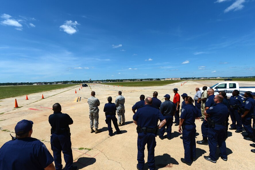 [From left] U.S. Air Force Airmen and Sumter Police Department officers watch a defensive driving demonstration at Shaw Air Force Base, S.C., Aug. 26, 2014. Approximately 20 police officers drove the course to complete their annual defensive driving requirement. (U.S. Air Force photo by Airman 1st Class Jensen Stidham/Released)