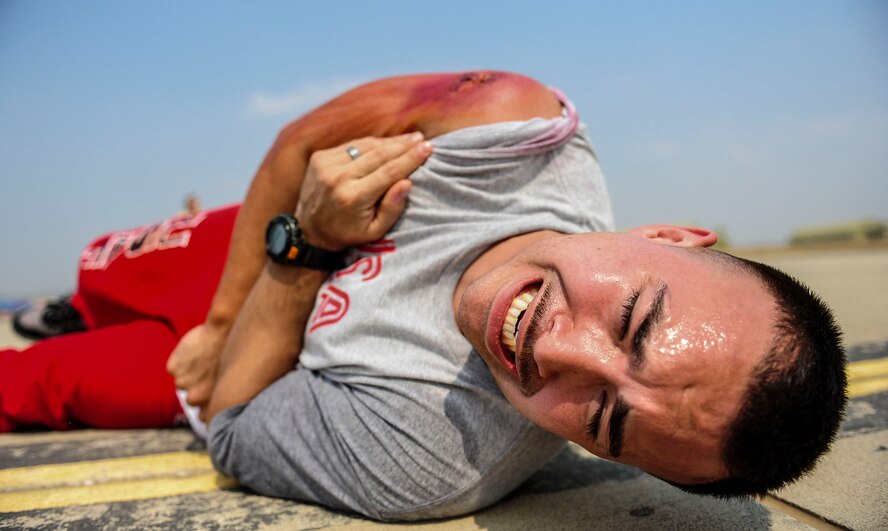 Senior Airman Richard Wesling, 39th Maintenance Squadron transportation alert crash recovery team member, screams out during a simulated medical emergency Aug. 28, 2014, Incirlik Air Base, Turkey. Medical responders attended to injured personnel during the wing-wide exercise which challenged Team Incirlik Airmen to respond to possible real world events. (U.S. Air Force photo by Senior Airman Nicole Sikorski/Released) 