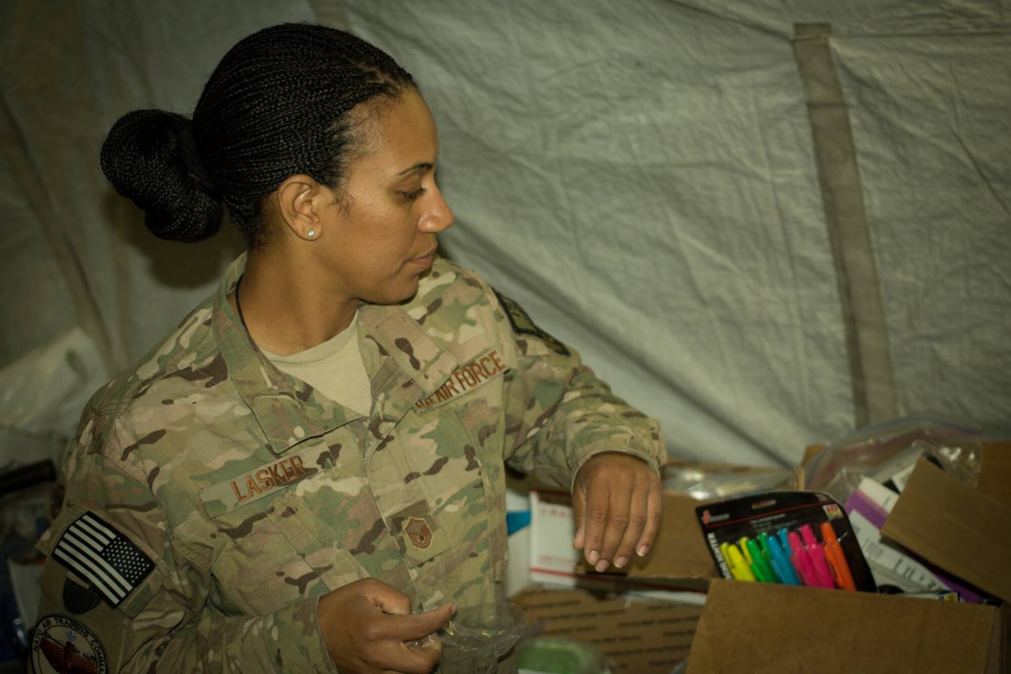 U.S. Air Force Master Sgt. Erin Lasker, 438th Air Expeditionary Advisory Group, helps sort and pack supplies for donation to family members of Afghan Air Force officers killed in a terrorist bombing July 2, 2014. A volunteer organization, Operation Outreach-Afghanistan, collected donations and presented them to the families of the fallen Afghan Airmen. (U.S. Air Force photo/Master Sgt. Eric B. Johnson)