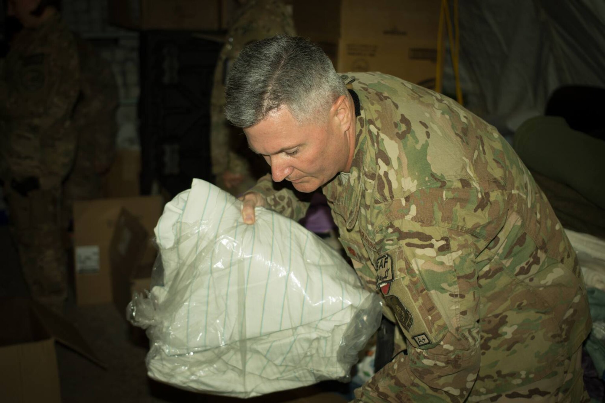 U.S. Air Force Maj. Sheldon Knudsen, NATO Air Training Command-Afghanistan and 438th Air Expeditionary Wing, helps sort and pack supplies for donation to family members of Afghan Air Force officers killed in a terrorist bombing July 2, 2014. A volunteer organization, Operation Outreach-Afghanistan, collected donations and presented them to the families of the fallen Afghan Airmen. (U.S. Air Force photo/Master Sgt. Eric B. Johnson)