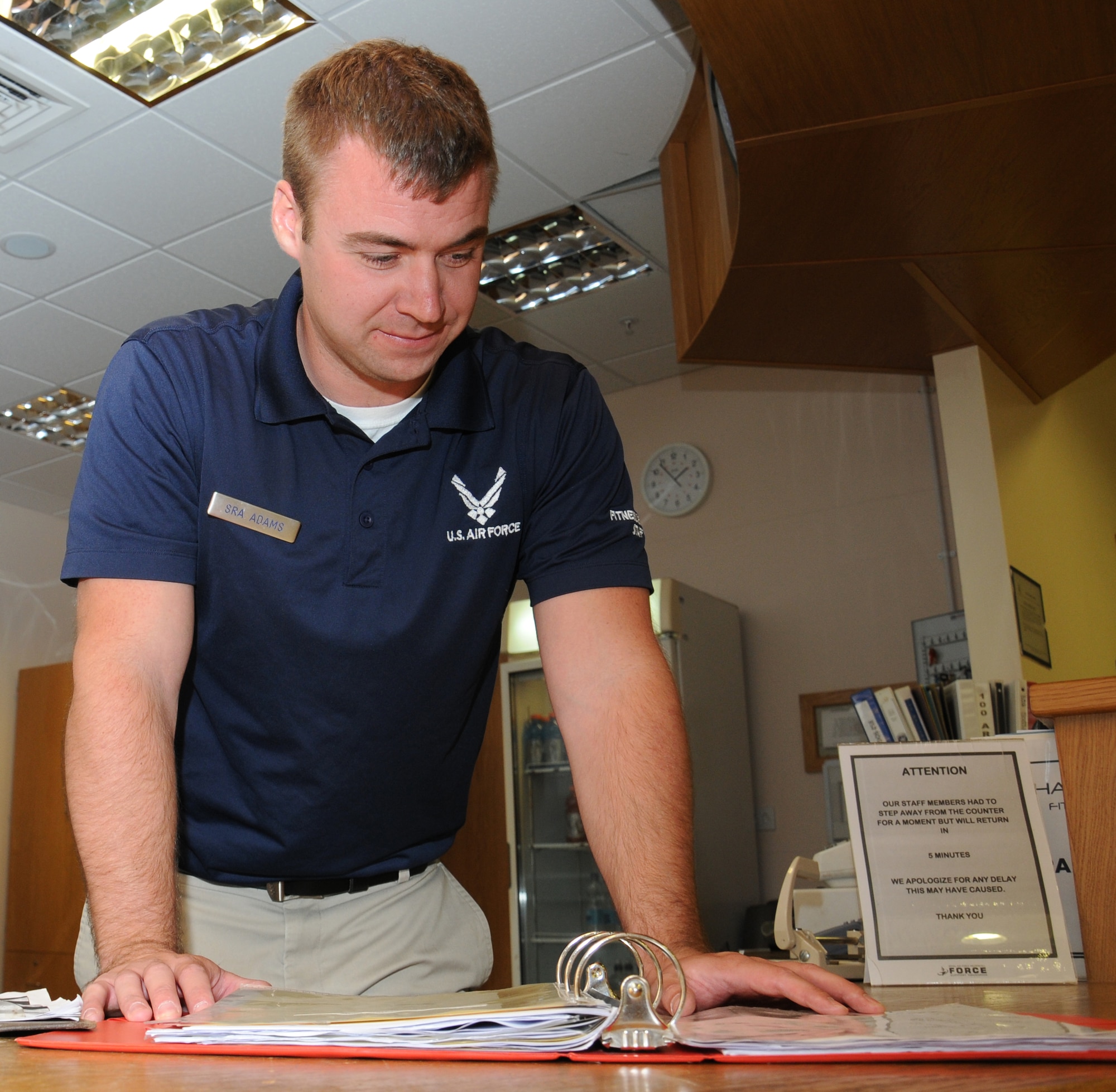 U.S. Air Force Senior Airman Corey Adams, 100th Force Support Squadron Sports director of the Hardstand Fitness Center from New Lothrop, Mich., checks a sports schedule Aug. 20, 2014, on RAF Mildenhall, England. In Adams’s career field, there are four parts to his job: food service, fitness, lodging or billeting, and the readiness section which handles mortuary affairs and honor guard. (U.S. Air Force photo/Gina Randall/Released)