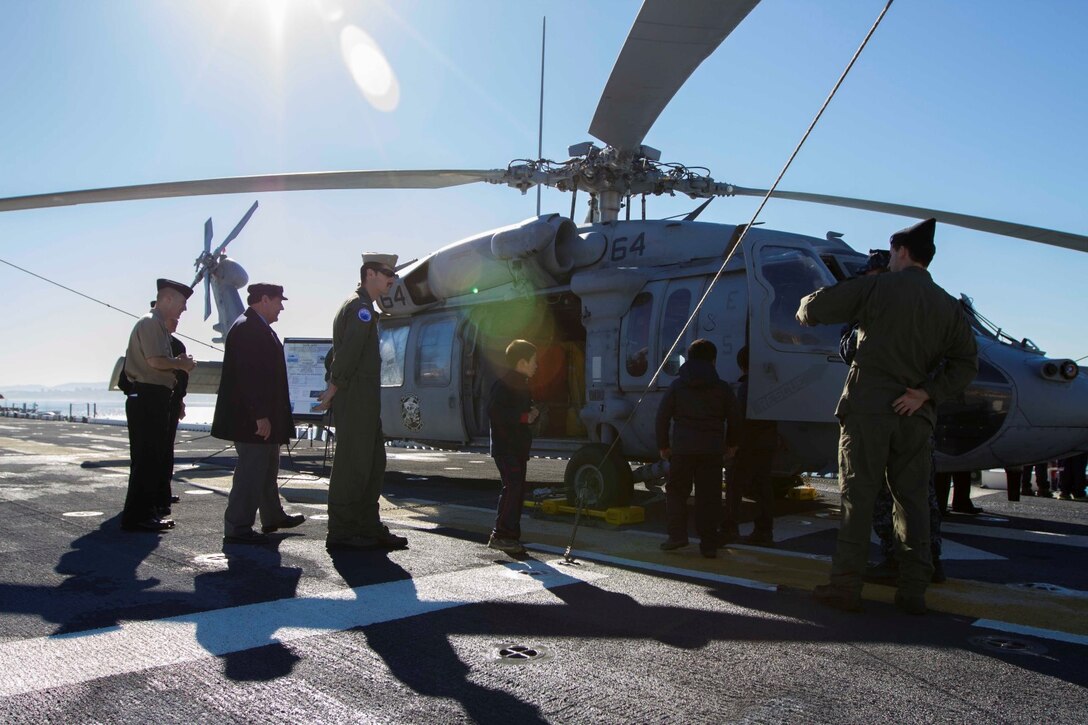 Children and staff from a local school are shown a MH-60S Seahawk at static display on the flight deck of the future amphibious assault ship USS America in Valparaiso, Chile, Aug. 25, 2014. The children were given the opportunity to get hands on with several static displays hosted by Marines and sailors showcasing the capabilities that Special Purpose Marine Air Ground Task Force South brings to the ship. SPMAGTF-South is embarked aboard America in support of her maiden transit “America Visits the Americas.” The transit demonstrates the capabilities that the Navy-Marine Corps team brings to our nation and partners.