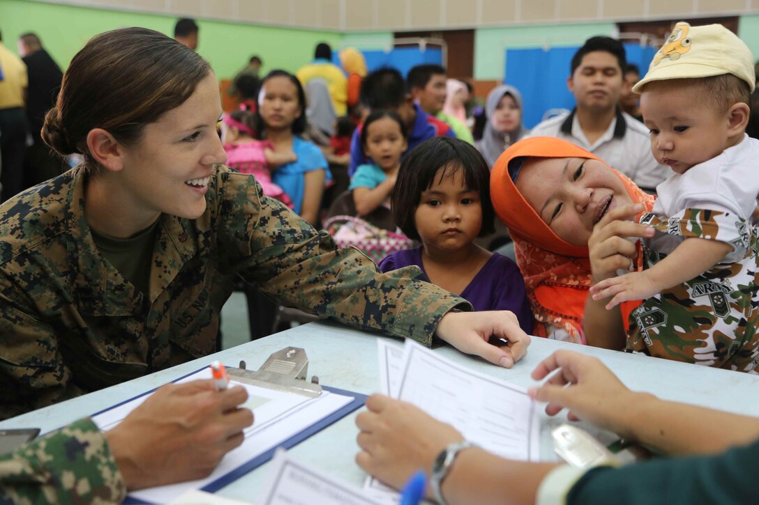 Lt. Shannon Meyer, with Combat Logistics Battalion 11, 11th Marine Expeditionary Unit, talks to Malaysian citizens about health issues during a medical and dental outreach partnered with the Royal Malaysian Medical Corps as part of Malaysia-United States Amphibious Exercise 2014. During the first day of the outreach, doctors and dentists treated 159 medical and 70 dental patients. MALUS AMPHEX 14 is a bilateral exercise between the 11th MEU and Malaysian Armed Forces that includes operational and tactical level training in planning, command and control, and combat service support using both ground and sea assets.