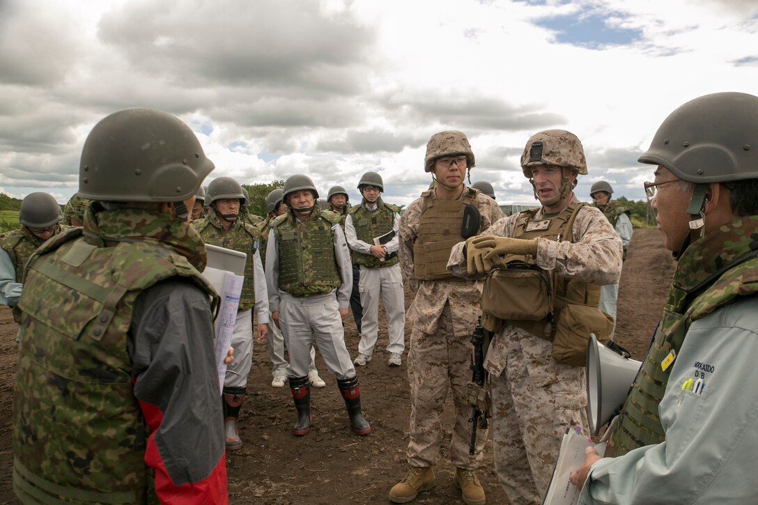 Lt. Col. Neil J. Owens, second from right, answers questions from local community officials during an observation tour Aug. 26 as part of Artillery Relocation Training Program 14-2 at the Yausubetsu Maneuver Area in Hokkaido. The observation tour opened ARTP 14-2 to the public and afforded them the opportunity to ask questions they had about the training. Owens is the commanding officer of 3rd Battalion, 12th Marine Regiment, 3rd Marine Division, III Marine Expeditionary Force. (U.S. Marine Corps photo by Cpl. Matthew Manning/Released)