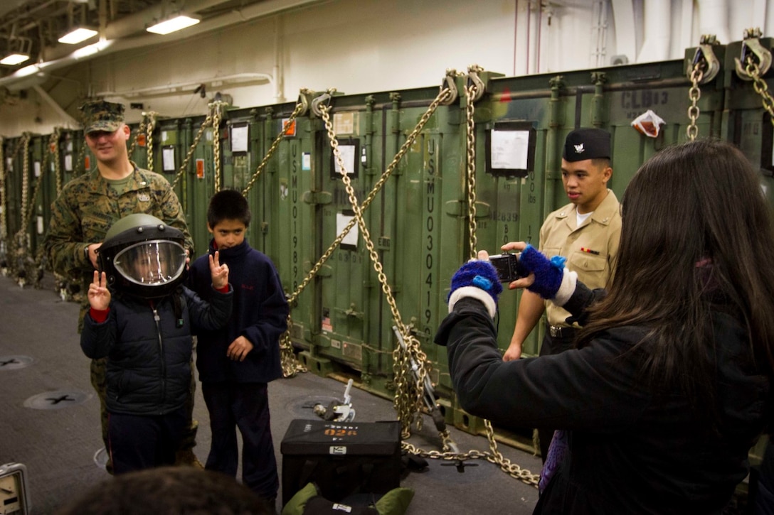 A student from a local school poses for a photo wearing a bomb suit helmet at an explosive ordnance disposal static display aboard the future amphibious assault ship USS America (LHA 6) in Valparaiso, Chile, Aug. 25, 2014. The children were given the opportunity to get hands on with several static displays hosted by Marines and Sailors showcasing the capabilities that Special Purpose Marine Air Ground Task Force South brings to the ship. SPMAGTF-South is embarked aboard America in support of her maiden transit “America Visits the Americas.” The transit demonstrates the capabilities that the Navy-Marine Corps team brings to our nation and partners. (U.S. Marine Corps photo by Cpl. Donald Holbert/ Released)
