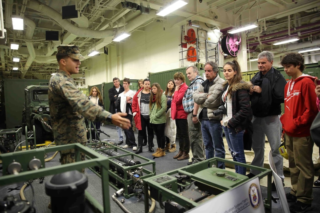 Corporal Christopher Cordero Vega, a combat engineer with Special Purpose Marine Air Ground Task Force South, and a native of Humacao, Puerto Rico, speaks about a light-weight water purification system to U.S. Embassy Staff and their families at a static display aboard the future amphibious assault ship USS America (LHA 6) in Valparaíso, Chile, Aug. 25, 2014. The visitors saw several static displays as part of a tour hosted by Marines and Sailors, showcasing the capabilities that the SPMAGTF brings to the ship. SPMAGTF-South is embarked aboard America in support of her maiden transit, “America Visits the Americas.” The transit demonstrates the capabilities that the Navy-Marine Corps team brings to our nation and partners. (U.S. Marine Corps photo by Cpl. Christopher J. Moore/Released)