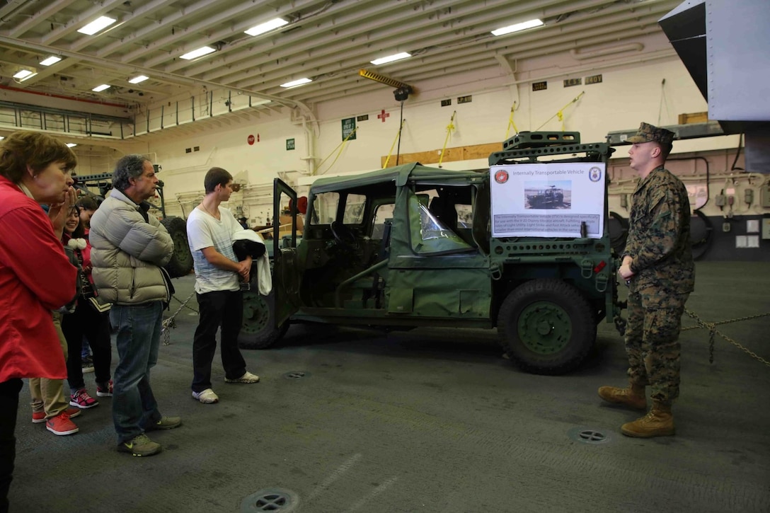 Corporal Dalton Kirkey, a fiscal chief with Special Purpose Marine Air Ground Task Force South, explains the internally transportable vehicle to U.S. Embassy Staff and their families at a static display aboard the future amphibious assault ship USS America (LHA 6) in Valparaíso, Chile, Aug. 25, 2014. The visitors saw several static displays as part of a tour hosted by Marines and Sailors, showcasing the capabilities that the SPMAGTF brings to the ship. SPMAGTF-South is embarked aboard America in support of her maiden transit, “America Visits the Americas.” The transit demonstrates the capabilities that the Navy-Marine Corps team brings to our nation and partners. (U.S. Marine Corps photo by Cpl. Christopher J. Moore/Released)