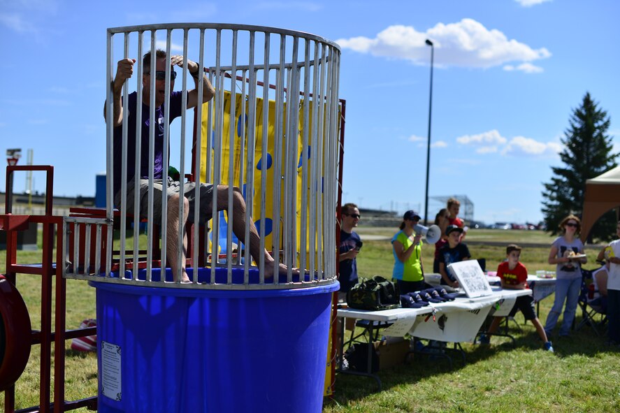 Col. John Wilcox, 341st Missile Wing commander, heckles the crowd from a dunk tank during the base picnic at Sun Plaza Park Aug. 28. More than 4,100 Airmen, DoD civilians, retirees and family members showed up at the park to enjoy some sun, food and fun during the base picnic. (U.S. Air Force photo/Tech. Sgt. Chad Thompson)