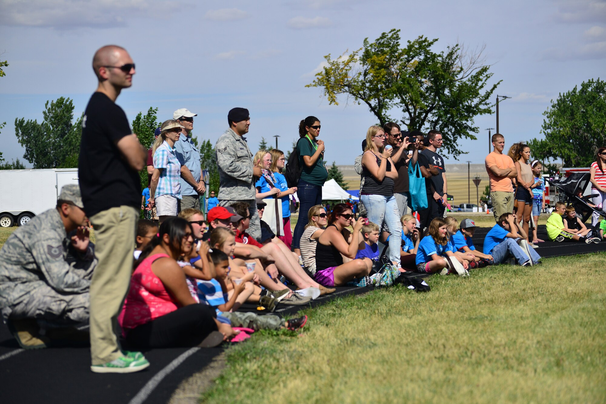 Onlookers watch a military working dog demonstration hosted by the 341st Security Forces Squadron military working dog handlers near the base track Aug. 28. More than 4,100 Airmen, DoD civilians, retirees and family members showed up at Sun Plaza Park to enjoy some sun, food and fun during the base picnic. (U.S. Air Force photo/Tech. Sgt. Chad Thompson)