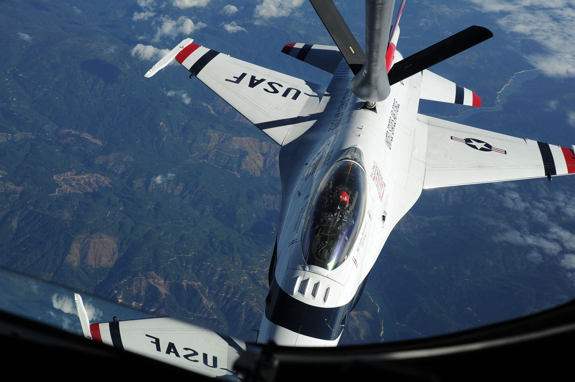 An F-16 Fighting Falcon with the U.S. Air Force Aerial Demonstration Squadron Thunderbirds refuels from a 92nd Air Refueling Wing KC-135 Stratotanker from Fairchild Air Force Base, Washington, over Glacier National Park, Montana, Sept. 1, 2014. The Thunderbirds tour all around the world performing for people and showcasing Air Force capabilities. (U.S. Air Force photo by Airman 1st Class Janelle Patiño/Released)