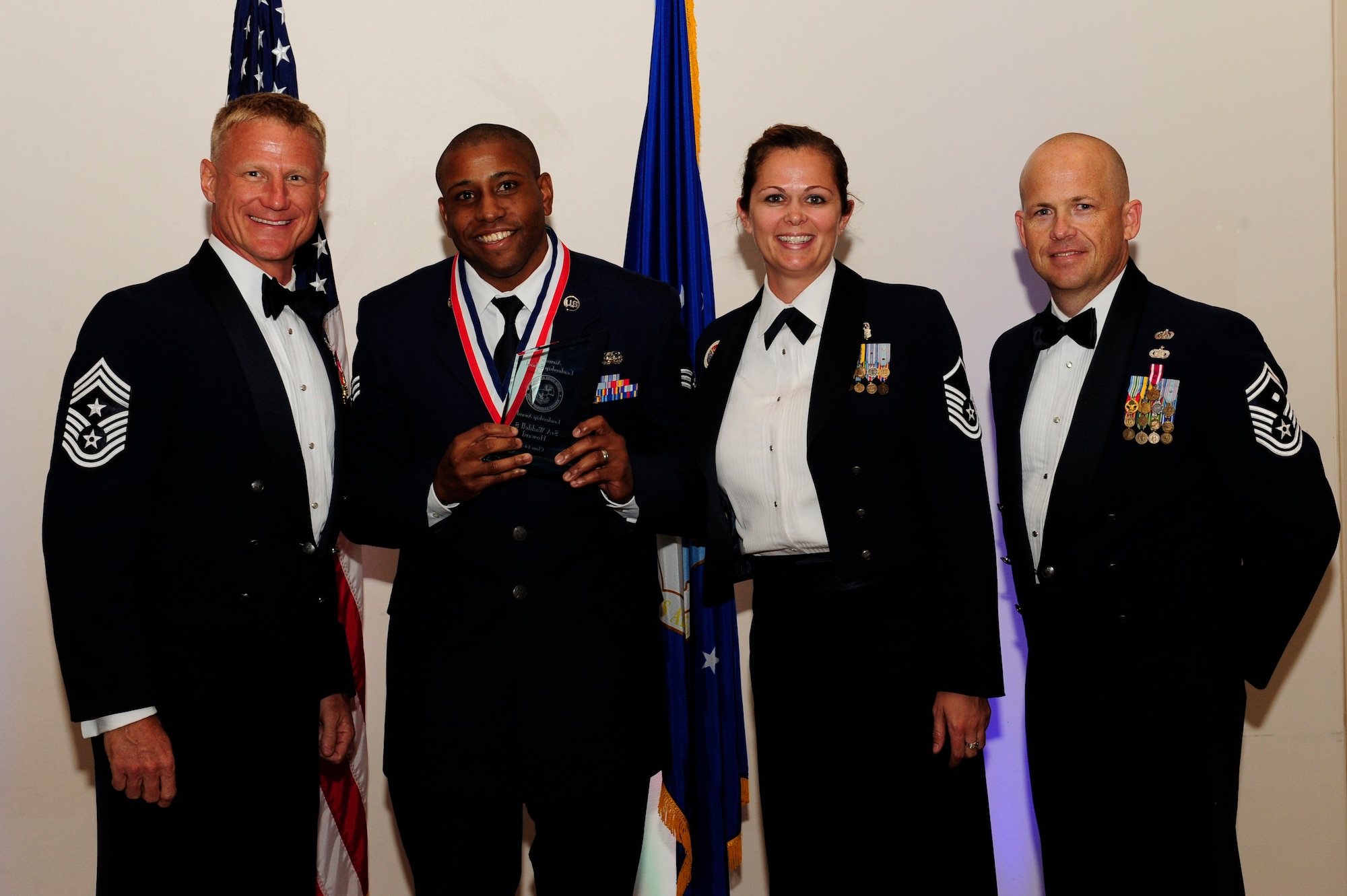 Senior Airman Waddell Howard, 460th Civil Engineer Squadron command program NCO in charge, second from left, receives the Leadership Award during the Buckley Airman Leadership School Class 14-F graduation Aug. 28, 2014, at the Leadership Development Center on Buckley Air Force Base, Colo. This award is presented to the ALS graduate who displays the best overall characteristics of an effective leader. (U.S. Air Force photo by Airman 1st Class Samantha Saulsbury/Released)