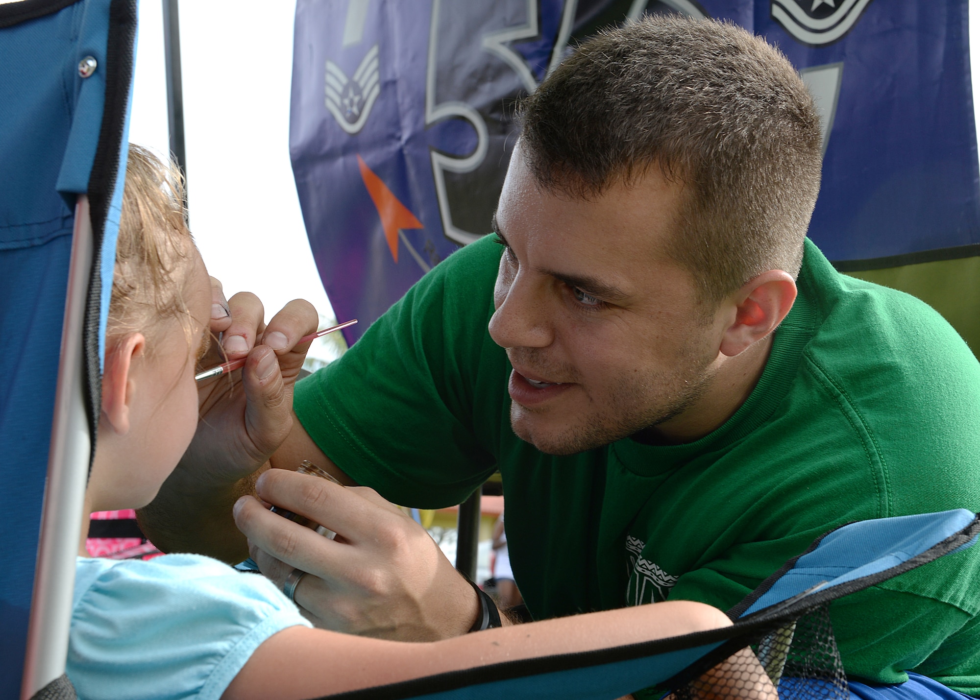 Staff Sgt. Robert Terwilliger, 36th Communications Squadron, paints a child’s face during the 2014 Labor Day Bash Sept. 1, 2014, on Andersen Air Force Base, Guam. The annual event featured several attractions such as carabao rides, raffle drawings and a pie-eating contest. (U.S. Air Force photo by Senior Airman Katrina M. Brisbin/Released)