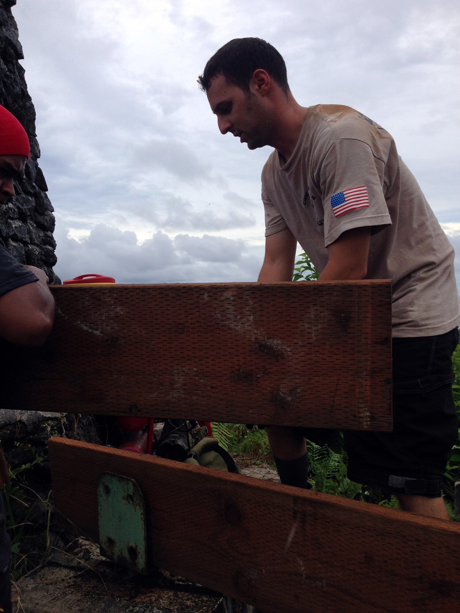 U.S. Air Force Tech. Sgt. Adam Leys installs floor joists on the new deck around the Bloody Nose Ridge Memorial, Peleliu, Republic of Palau. The CAT-Palau team consisted of 13 Airmen and 13 Palauan apprentices who worked over eight days to complete the project. (Courtesy photo/Released)