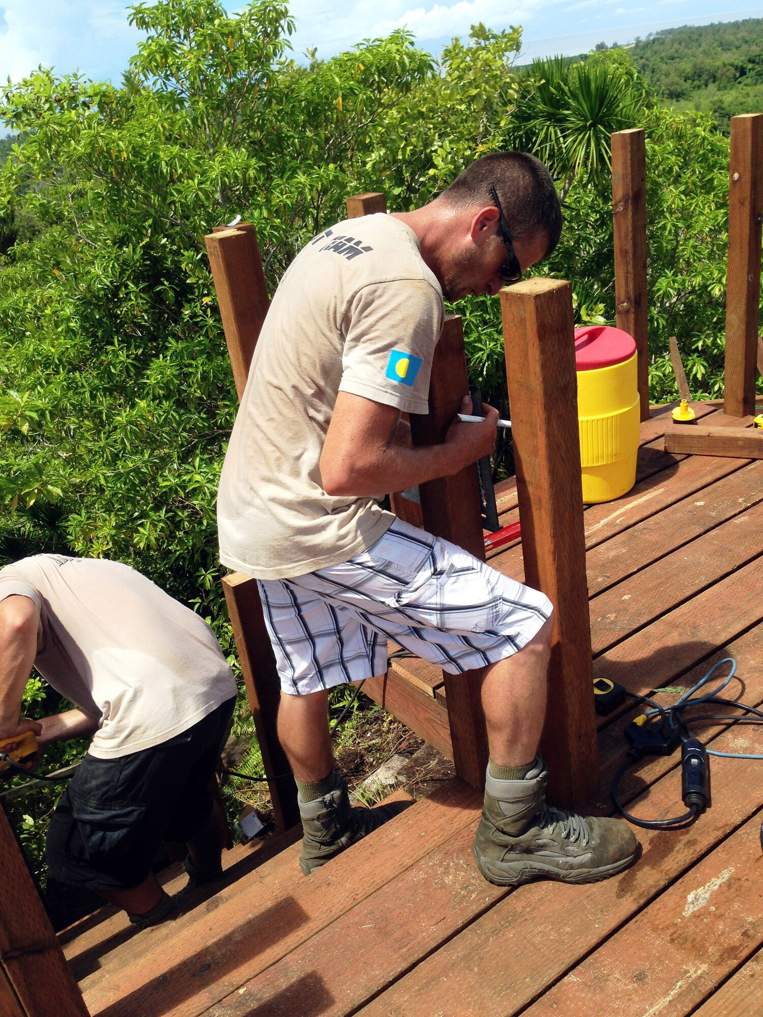U.S. Air Force Staff Sgt. Dan Frick, Civic Action Team-Palau member, measures the cuts on the new stair railing as part of the restoration project of the Bloody Nose Ridge Memorial deck, Peleliu, Republic of Palau. The CAT-Palau team consisted of 13 Airmen and 13 Palauan apprentices who worked over eight days to complete the project. (Courtesy photo/Released)