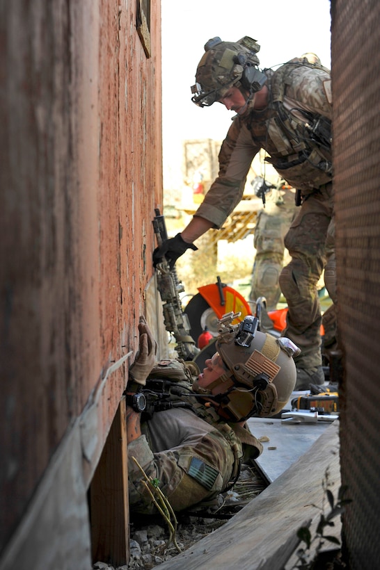 U.S. Air Force Staff Sgt. Jason Lee, bottom, pulls himself out of a crawlspace as U.S. Air Force Senior Airman Joseph Brady tends to equipment during a mission rehearsal on Bagram Airfield, Afghanistan, Aug. 26, 2014. Lee and Brady are pararescuemen assigned to the 83rd Expeditionary Rescue Squadron.