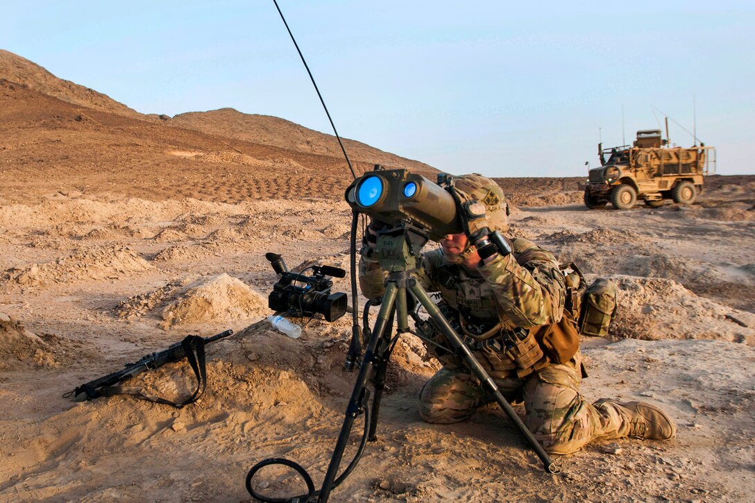 U.S. Army Sgt. Daniel Hoffman looks through a long-distance laser rangefinder to get measurements for an artillery exercise on Kandahar Airfield, Afghanistan, Aug. 22, 2014. Hoffman is a fire support noncommissioned officer assigned to the 4th Infantry Division's Company D, 1st Battalion, 12th Infantry Regiment, 4th Infantry Brigade Combat Team.