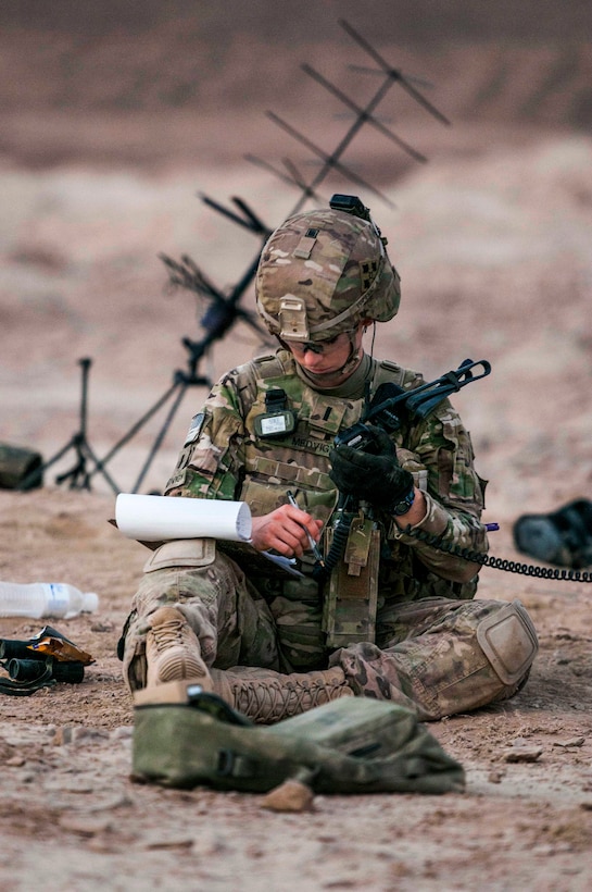 U.S. Army 1st Lt. Elyse Ping Medvigy writes coordinates on her notepad in preparation for an artillery shoot on Kandahar Airfield, Afghanistan, Aug. 22, 2014. Medvigy is a fire support officer assigned to the 4th Infantry Division's Company D, 1st Battalion, 12th Infantry Regiment, 4th Infantry Brigade Combat Team.