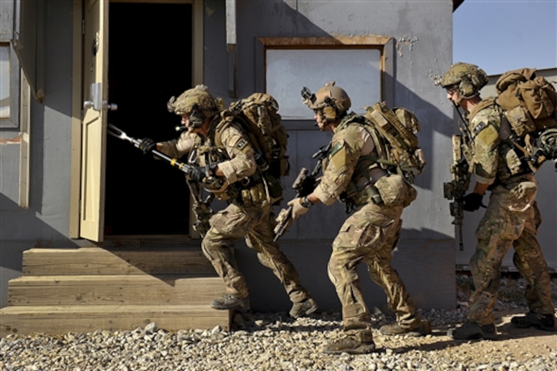 U.S. Air Force Senior Airman Joseph Brady, Staff Sgt. Jason Lee, and Senior Airman Thomas Schalin, breach a door and prepare to clear a room during a mission rehearsal on Bagram Airfield, Afghanistan, Aug. 26, 2014. Brady, Lee and Schalin are assigned to the 83rd Expeditionary Rescue Squadron.