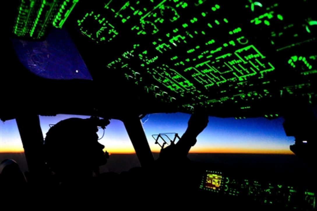 U.S. Air Force Capt. Erica Stooksbury adjusts the cockpit lighting controls as the sun rises after a humanitarian airdrop mission over Amirli, Iraq, Aug. 31, 2014. Stooksbury is a C-17 Globemaster III pilot assigned to the 816th Expeditionary Airlift Squadron.