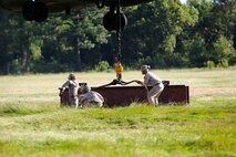 Marines with Combat Logistics Battalion 26, 2nd Marine Logistics Group connect a metal beam to a CH-53E Super Stallion helicopter during external lift training aboard Camp Lejeune, N.C., Aug. 27, 2014. Marines with Helicopter Support Team, CLB-26 partnered with Marine Heavy Helicopter Training Squadron 302, Marine Aircraft Group 29, 2nd Marine Air Wing, to practice single and dual point cargo lifts.