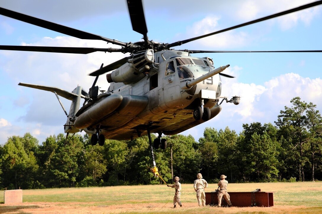 Marines with Combat Logistics Battalion 26, 2nd Marine Logistics Group prepare to connect a metal beam to a CH-53E Super Stallion helicopter during external lift training aboard Camp Lejeune, N.C., Aug. 27, 2014. Marines with Helicopter Support Team, CLB-26 partnered with Marine Heavy Helicopter Training Squadron 302, Marine Aircraft Group 29, 2nd Marine Air Wing, to practice single and dual point cargo lifts.