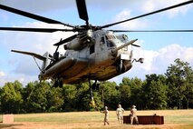 Marines with Combat Logistics Battalion 26, 2nd Marine Logistics Group prepare to connect a metal beam to a CH-53E Super Stallion helicopter during external lift training aboard Camp Lejeune, N.C., Aug. 27, 2014. Marines with Helicopter Support Team, CLB-26 partnered with Marine Heavy Helicopter Training Squadron 302, Marine Aircraft Group 29, 2nd Marine Air Wing, to practice single and dual point cargo lifts.