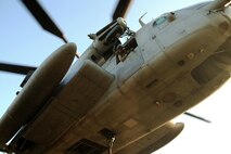 A crew chief with Marine Heavy Helicopter Training Squadron 302, Marine Aircraft Group 29, 2nd Marine Air Wing, observes the helicopter support team Marines below as they connect a metal beam to a hook dangling below the helicopter aboard Camp Lejeune, N.C., Aug. 27, 2014. Marines with HST, Combat Logistics Battalion 26, 2nd Marine Logistics Group partnered with HMHT-302 to practice single and dual point cargo lifts.