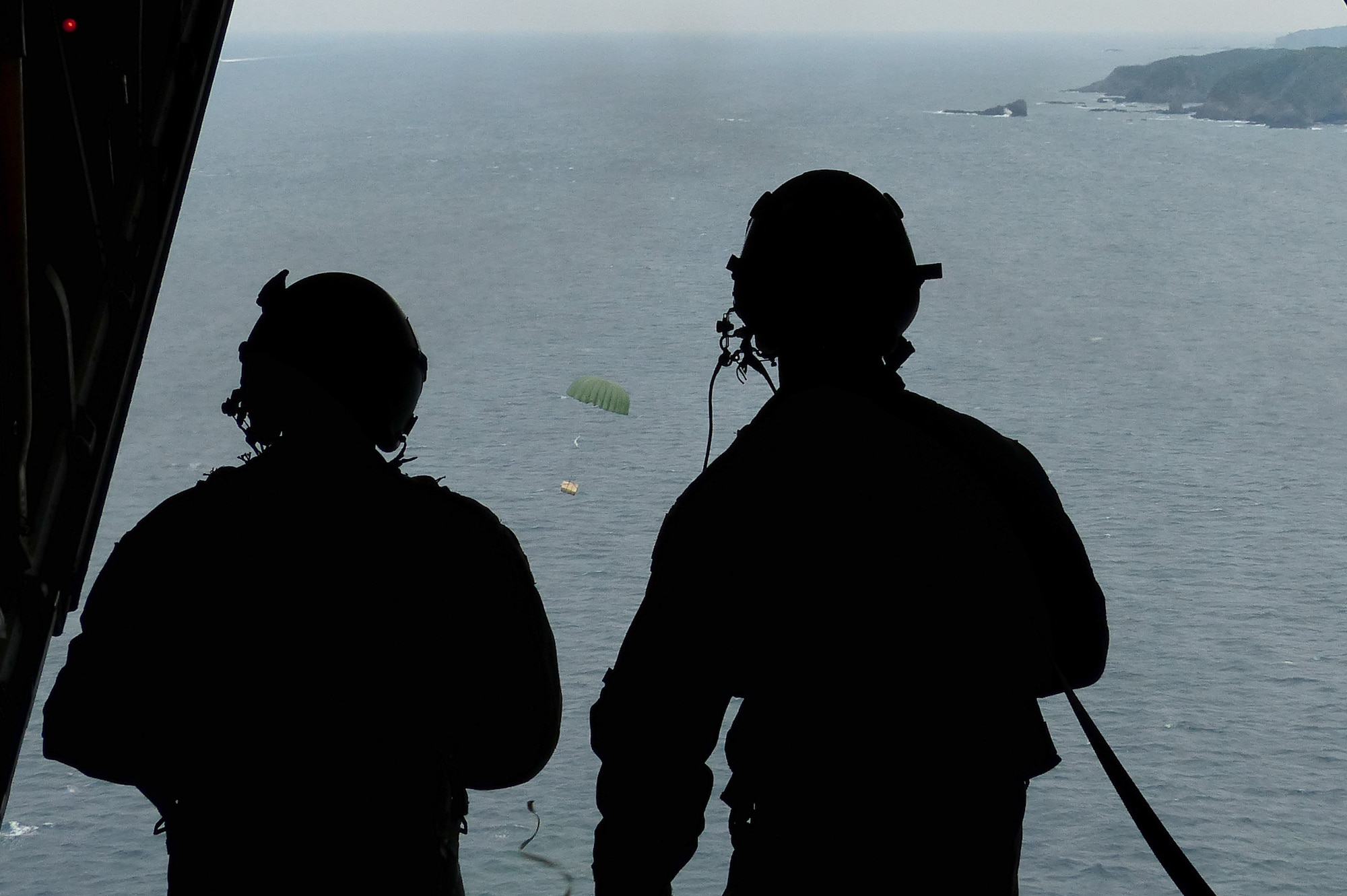 Airman 1st Class Dillon Howell, left, and Staff Sgt. Napoleon Ortiz watch a low-cost, low-altitude airdrop bundle hit its target during a bilateral disaster relief exercise Aug. 31, 2014, supporting Shizuoka prefecture government. The LCLA bundle contained 300 pounds of rice and water that was retrieved by Japanese fishermen. Airmen from the 374th Airlift Wing participated in three disaster management exercises with Japanese first responders and an additional joint exercise with Marine counterparts Aug. 30 and 31. Howell and Ortiz are  loadmasters assigned to the 36th Airlift Squadron, Yokota Air Base, Japan. (U.S. Air Force photo/1st Lt. Jake Bailey)